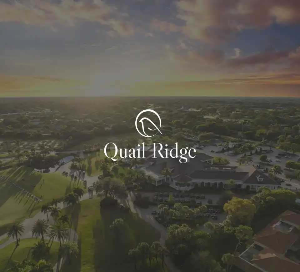 Aerial sunrise view of golf community with Quail Ridge logo centered over image.