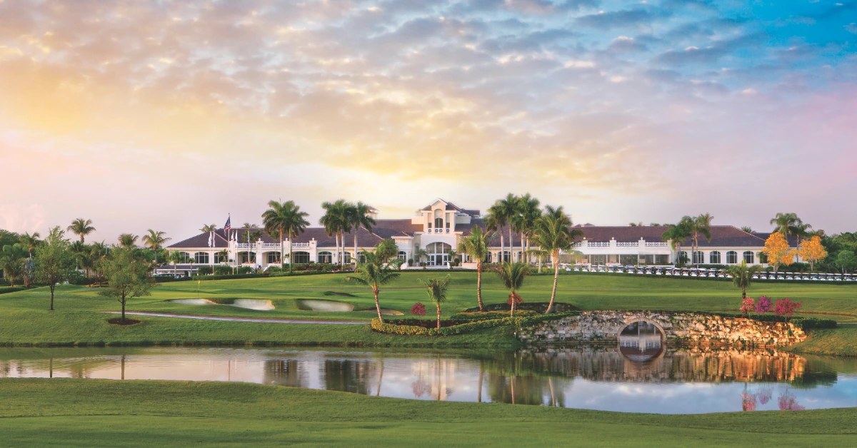 Clubhouse overlooking golf course and water at sunset