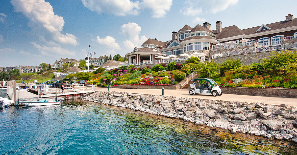 Waterfront yacht club building with marina docks, boats, and landscaped shoreline