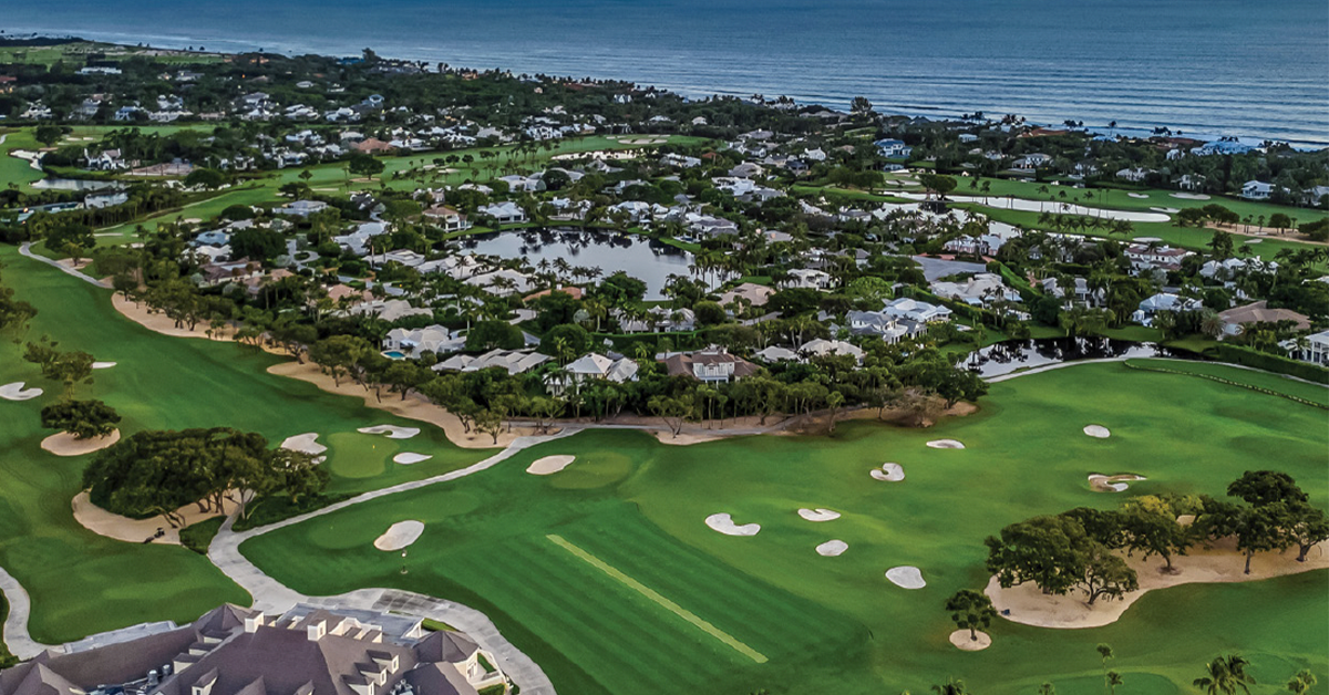 Players competing in a doubles pickleball match on an outdoor blue court