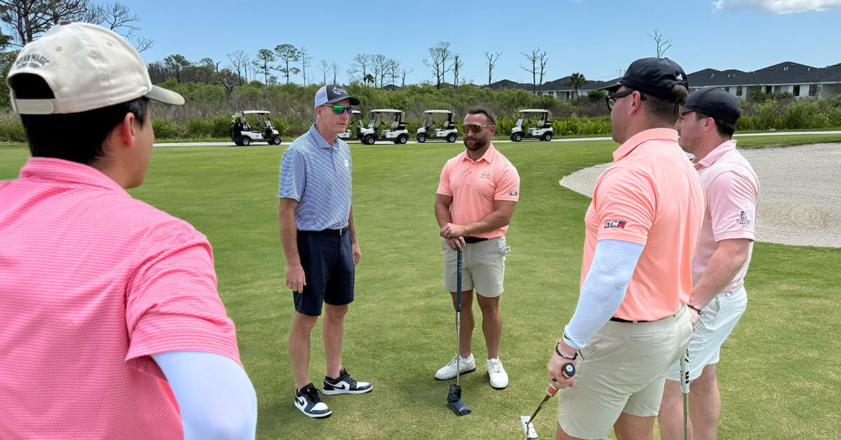 Group of golfers discussing play on green with Jim Furyk